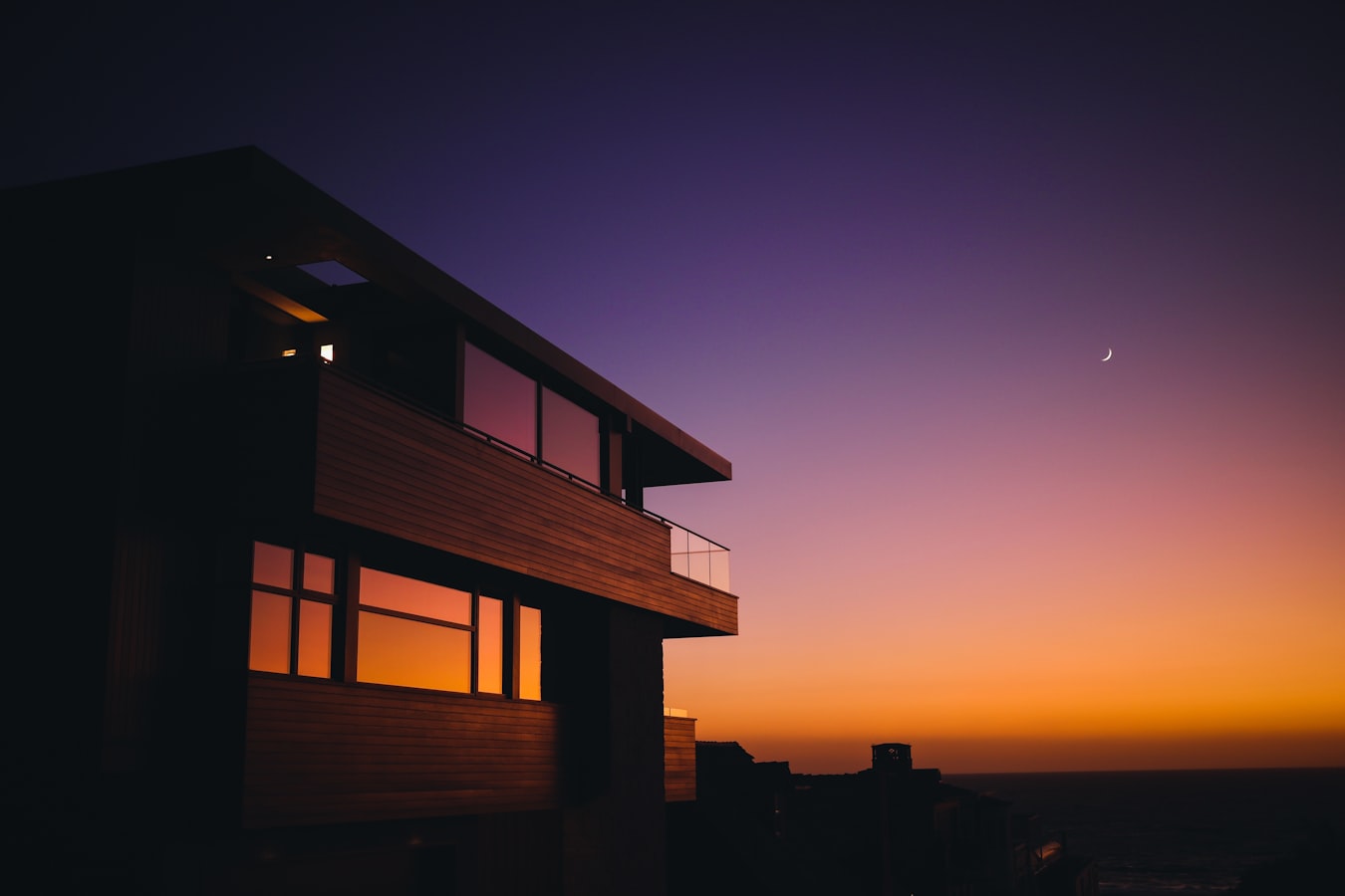 A family home at dusk with the interior lights on
