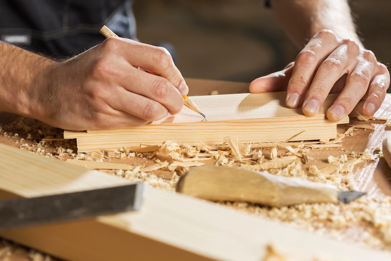 A craftsman marking out timber by hand in a workshop