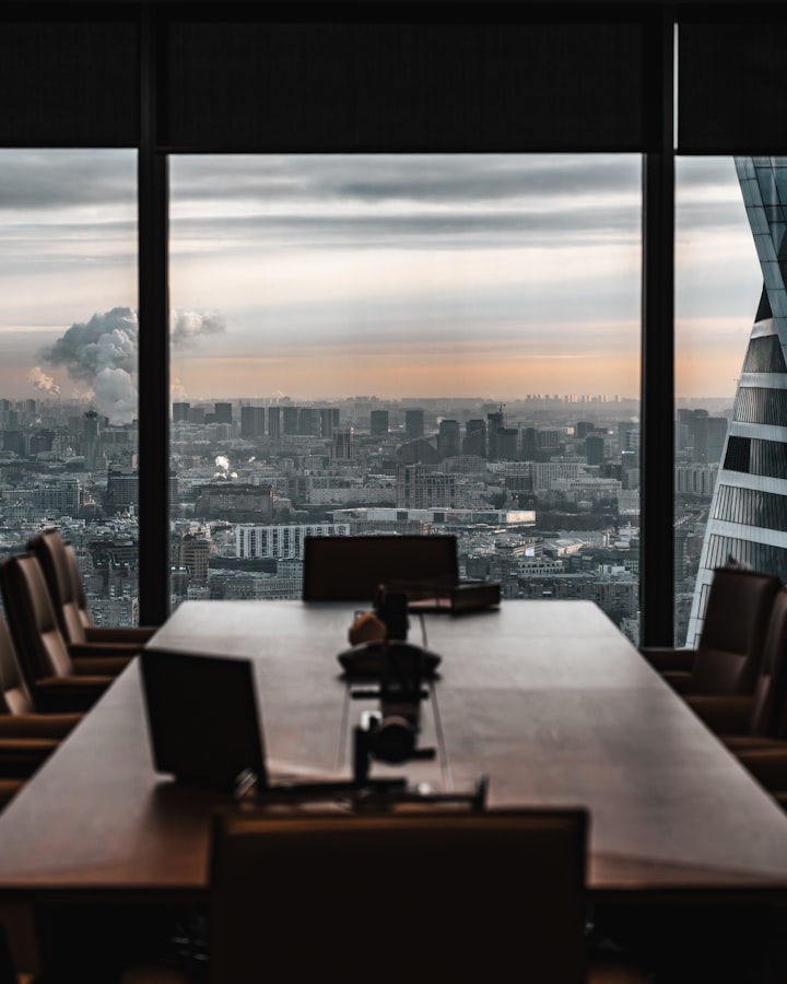 An empty boardroom overlooking a city at first light