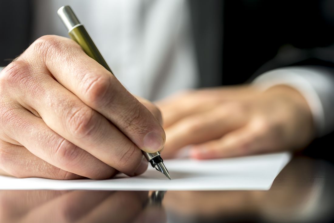 Close-up of a fountain pen and paper during a personal insurance advice meeting