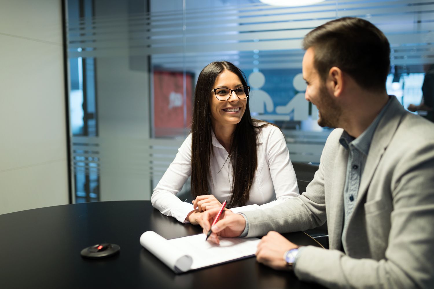 Adviser and client reviewing an insurance policy together at a desk